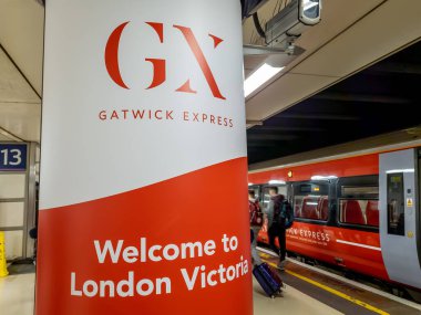 Londra Victoria.UK-05.13.2023.Londra Victoria tren istasyonundaki Gatwick Ekspres tren seferinin işareti ve treni..