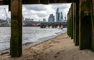 Londra mı? UK- 05.17.2023. Thames Nehri 'nin güney kıyısındaki Thames Sahili' nin rıhtımının altından Londra şehrindeki gökdelenleri gören bir manzara..