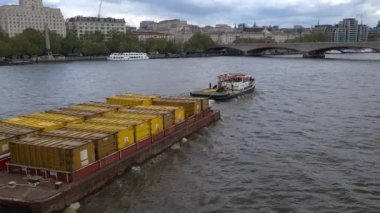 Londra mı? UK- 05.17.2023. Nakliye konteynırlarıyla dolu mavnaları çeken bir römorkör. Malların Thames Nehri 'nde su yoluyla taşınması.