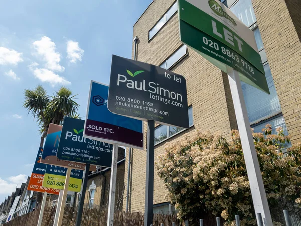 Londra mı? UK- 05.24.2023. Bir apartman bloğunun dışındaki emlakçılardan imza almak için bir sıra daire..