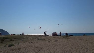 Lefkada adası. Yunanistan - 06.21.2023. Uçurtma sörfçülerinin buluşmasına yaklaşıyoruz. Kumsalda dinleniyorlar ve sporlarının tadını çıkarıyorlar..