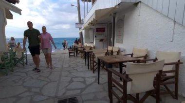 Lefkada adası. Yunanistan - 06.17.2023. Agios Nikitas 'taki sahil ve deniz kenarına doğru yürüyorum.