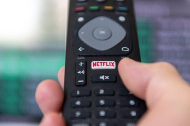 London. UK- 09.13.2023. A person using the remote control to access the popular streaming entertainment service provider Netflix. clipart