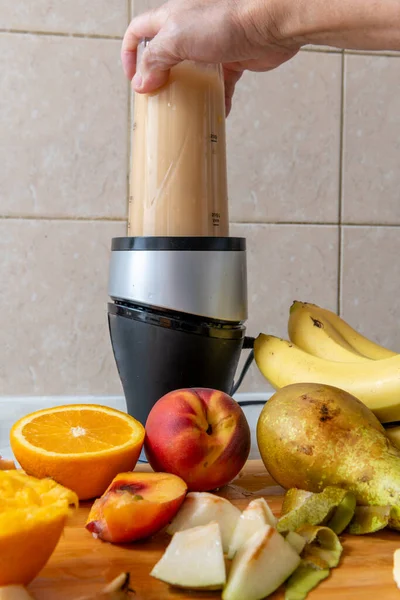 Making a smoothie with fresh fruits in a blender. Healthy life style, health food concept.