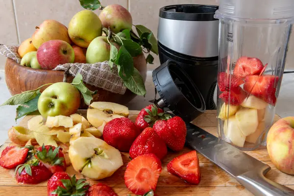 Making a smoothie with fresh fruits in a blender. Healthy life style, health food concept.