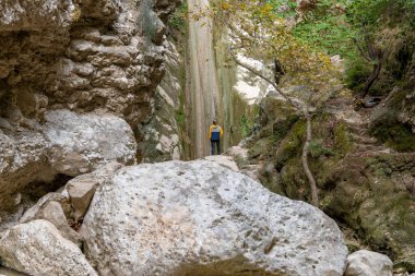 Lefkada adası. Yunanistan... 10.19.2023. Üssün yanında duran ve Nydri Şelalesine bakan bir turist..