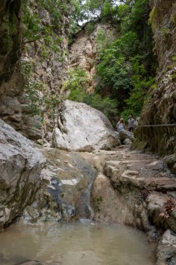 Lefkada adası. Yunanistan... 10.19.2023. Irmağı takip eden turistler Nydri şelalesine gidip geliyorlar..