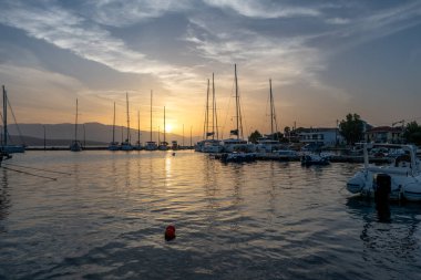 Gün doğumu bulutları ve yansımaları. Nikiana Limanı. Lefkada. Yunanistan.