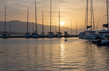 Gün doğumu bulutları ve yansımaları. Nikiana Limanı. Lefkada. Yunanistan.