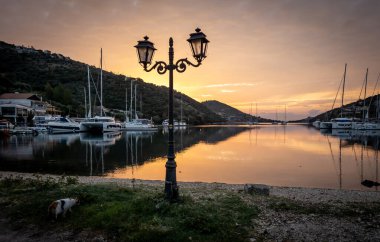Gün doğumu bulutları durgun deniz limanında yansıyor. Sivota. Lefkada. Yunanistan.