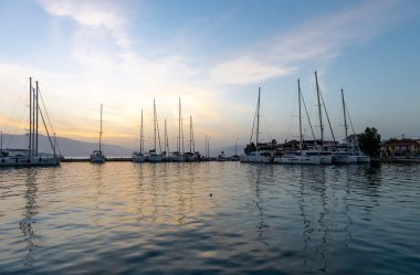 Gün doğumu bulutları ve yansımaları. Nikiana Limanı. Lefkada. Yunanistan.