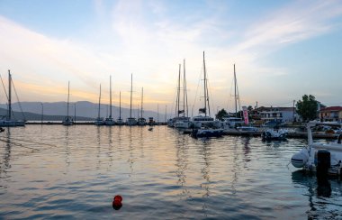 Gün doğumu bulutları ve yansımaları. Nikiana Limanı. Lefkada. Yunanistan.