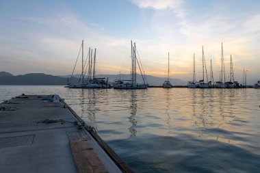 Gün doğumu bulutları ve yansımaları. Nikiana Limanı. Lefkada. Yunanistan.