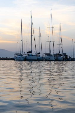 Gün doğumu bulutları ve yansımaları. Nikiana Limanı. Lefkada. Yunanistan.