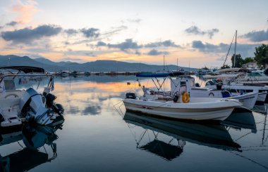 Gün doğumu bulutu durgun deniz limanına yansıyor