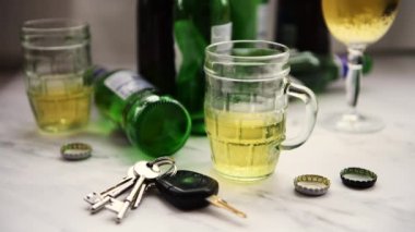 Alkollü içeceklerle dolu bir masayı içtikten sonra araba anahtarlarını alan bir insanın içki sürücüsü konsepti..