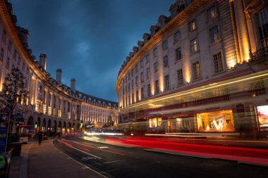 Londra mı? UK- 01.21.2024. Batı yakasındaki Regent Caddesi 'nin gece görüşü. Bina aydınlanıyor ve araçlardan gelen ışık izleri var.