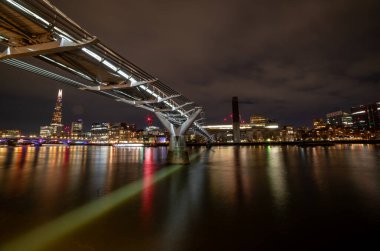 Londra mı? İngiltere-01.20.2024. Gece vakti Milenyum Köprüsü 'nün Thames Nehri' ne yansıyan ışıklarıyla uzun pozlu görüntüleri..