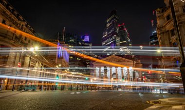 Londra mı? Birleşik Krallık-01.27.2024. Bir gece vakti, Londra şehrinin uzun pozlama görüntüsü Royal Exchange, Bank of England ve arka planda gökdelenler ve geçen araçların ışık yollarını gösteriyor..