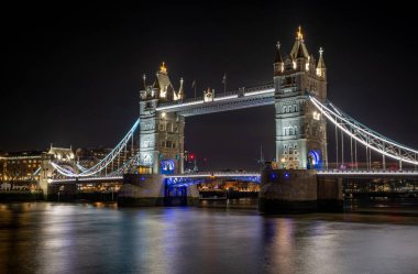 Bir gece vakti, Queens Köprüsü 'nden Tower Bridge Thames Nehri' nin güney kıyısında renkli ışıklar ve suda güzel ışık yansımaları gösteren bir köprü..