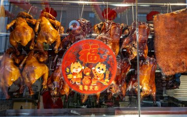 Londra mı? UK- 02.11.2024. Ay Yeni Yılı kutlamaları sırasında Çin Mahallesi 'ndeki bir Çin restoranının vitrininde leziz kızarmış etler ve servet çıkartması..