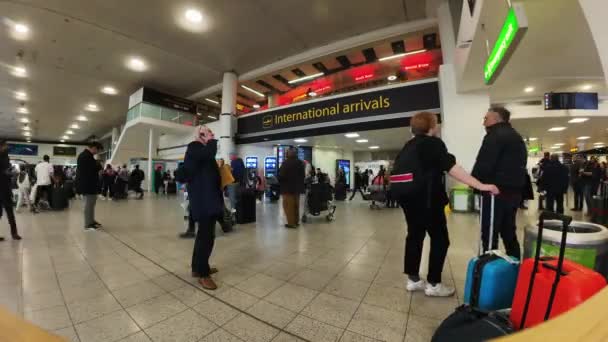 ガトウィック空港 イギリス 2024 南ターミナルで非常に忙しい国際到着ホールの時間の経過と乗客の群衆 — ストック動画