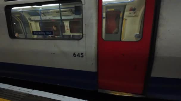 ロンドン イギリス 2024 到着したロンドン地下鉄のビュークリップと プラットフォームから乗客が列車に乗り込むドアを開けます — ストック動画