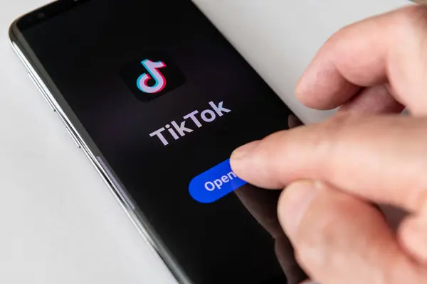 Londra mı? UK- 04.18.2024.Video sosyal medya uygulaması TikTok ve şirket logosu uygulamayı açmak için parmaklarıyla bir akıllı telefonun ekranında.