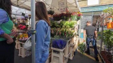 Londra mı? Birleşik Krallık-05.05.2024. Kolombiya Yolu Çiçek Pazarı 'nda sergilenen çiçeklerle dolu çiçek tezgahları. Bir sürü ziyaretçi onları arıyor ve satın alıyor..