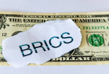 A dedollarisation concept with the word BRICS on top of a US dollar bill  isolated in white. clipart