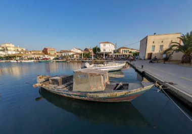 Lefkada Kasabası, Lefkada, Yunanistan - 06.30. 2024. Gezinti güvertesinin genel manzarası, su kanalında geleneksel ahşap küçük tekneleri olan başkent binaları..
