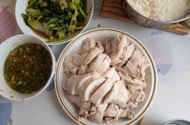 Geleneksel Çin usulü haşlanmış tavuk zencefil, taze soğan sosu, kızarmış yeşil sebze ve pilav ile servis edilir..