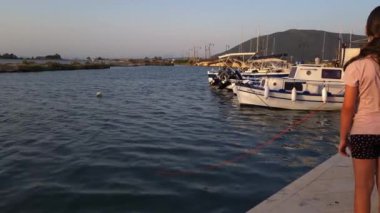 Lefkada Town, Lefkada, Yunanistan-06.30. 2024. Bir adam ve çocuklar su kanalında mıknatıs kullanarak metal nesneler avlıyorlar. Mıknatıs.