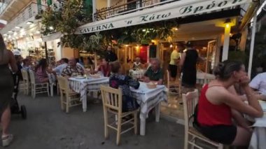 Lefkada Town, Lefkada, Yunanistan-06.30. 2024. Turistler tavernalarda yiyip akşamları Mela Caddesi 'nde alışveriş yapıyorlar..