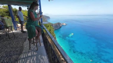 Athani, Lefkada, Yunanistan-07.01.2024. Cafe Panorama 'daki müşteriler dramatik uçurum manzarasının keyfini çıkarıyor ve filme çekiyor..