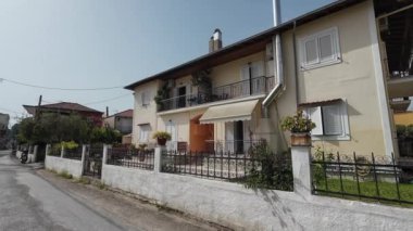 Nidri, Lefkada, Yunanistan-07.02.2024. Ana caddenin sonundaki evler, turizme hizmet etmek için stüdyo ve apartman olarak inşa edildi..