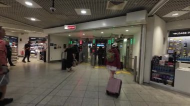 Gatwick Havaalanı, UK-07.03.2024. Güney Terminali 'nin kontrol bölgesinden giriş salonuna doğru giden bir yolcunun görüntüsü..