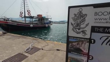 Nidri, Lefkada, Yunanistan-07.02.2024. Bir reklam teknesi seyahatleri ve geleneksel Yunan tasarımından oluşan küçük ahşap bir gemi hizmet sunuyor..