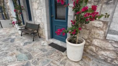 Karya Köyü, Lefkada, Yunanistan-07.02.2024. Küçük bir ön balkonu olan ve güzel saksı çiçekleri ile güçlendirilmiş geleneksel bir Yunan taş evinin cephesi..