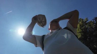 Sıcak bir yaz gününde, sıcak ve içme suyu hisseden yaşlı bir adamın düşük açılı görüntüsü..