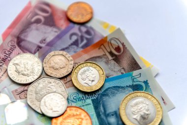 Kağıt banknotlar halinde Sterling fiziksel para biriminin tamamı ve beyaz arka planda izole edilmiş metal paralar..