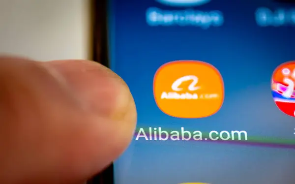 stock image London. UK- 07.28.2024. The Chinese multinational e-commerce app Alibaba on the screen of an Android phone and a finger going forward to open the application.