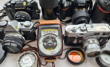 Londra mı? UK- 09.03.2024. Klasik ve modern çağın dijital SLR 'leri, lensleri ve beyazla izole edilmiş diğer ekipmanlardan oluşan bir koleksiyon