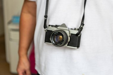 Klasik bir SLR fotoğraf makinesi taşıyan biri..