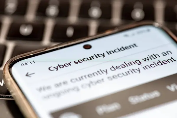 stock image Close up of a message on a mobile phone from a company informing its clients of an ongoing cyber security incident.