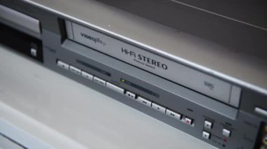 Londra mı? UK- 09.18.2024. Antika bir video oynatıcıya video kaset yerleştiren bir kişi.