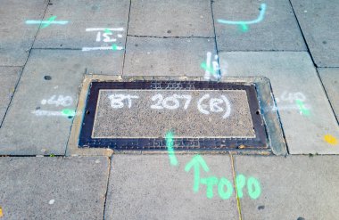 London. UK-09.20.2024. Survey engineer's  markings on the street manhole for British Telecom infrastructure work. clipart