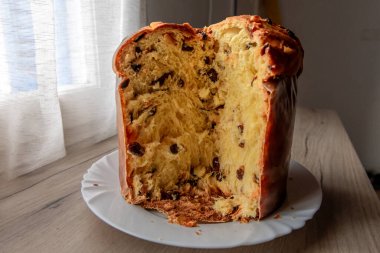İtalyan panettone, büfenin üzerinde noel pastası, içinde meyve ve dokuları gösteren bir dilim..