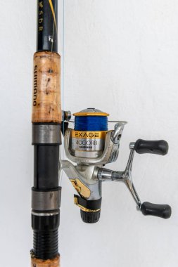 Lefkada, Yunanistan... 10.04.2024. Japon şirketi Shimano tarafından üretilen, beyaz bir arka planda izole edilmiş, balık oltalı bir olta..