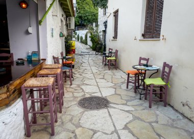Lefkada, Yunanistan... 10.15.2024. Popüler tatil köyü tatil beldesi Agios Nikitas 'ta bir bar ve el freski olan pitoresk bir ara sokak..